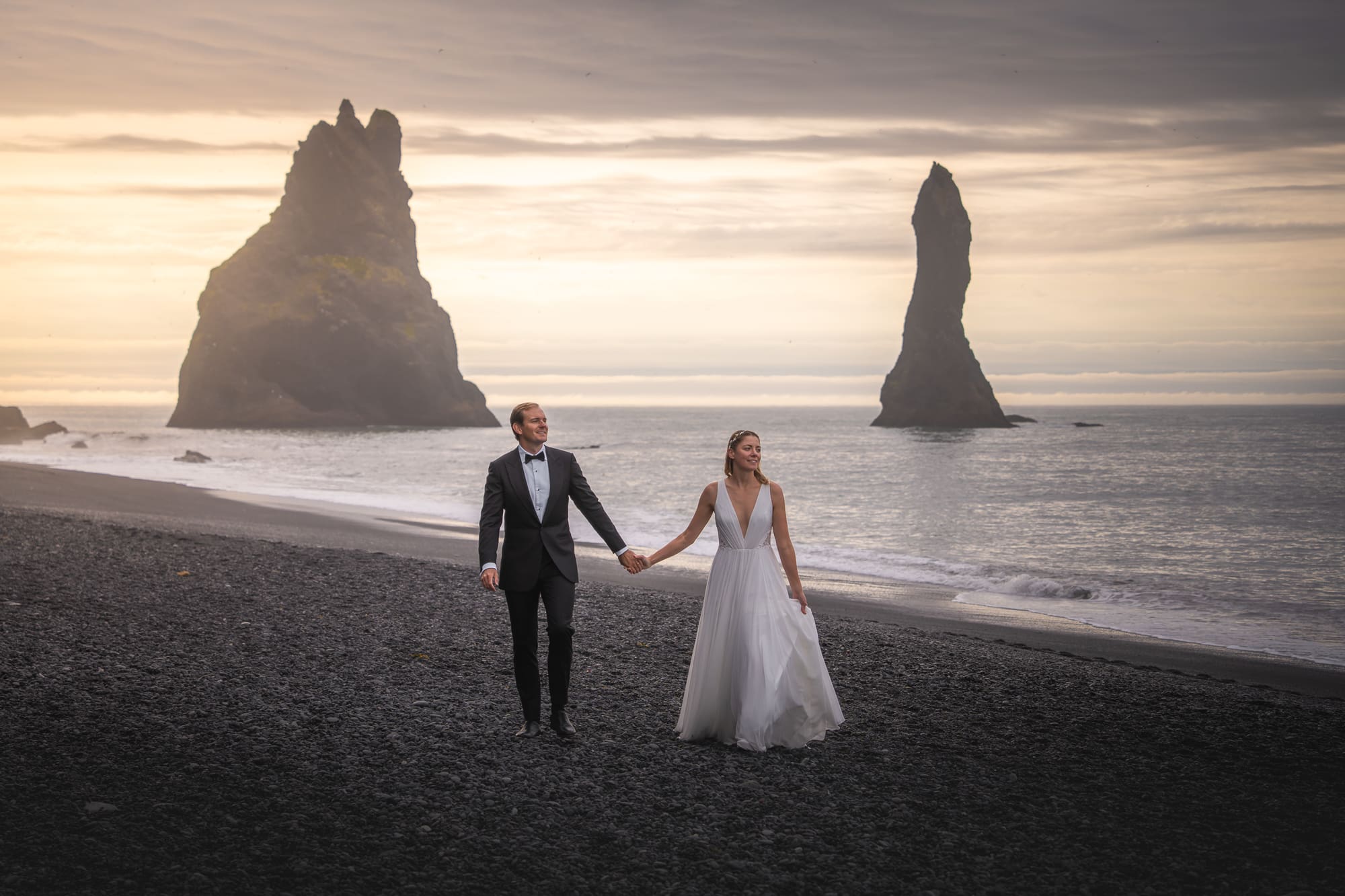 Bride and groom eloping at sunrise on Reynisfjara black sand beach in Iceland